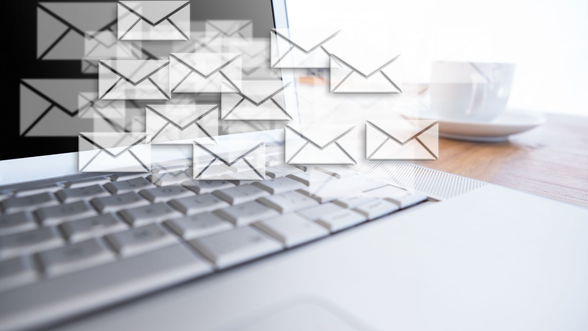 Ordenador portátil con iconos de correos electrónicos superpuestos, simbolizando el envío masivo de emails y posibles riesgos de ciberseguridad en empresas.
